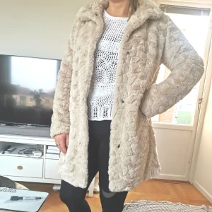 Kort kappa - Kappa som går halvvägs ner på låren. Helt oanvänd. "Fuskpäls wibe". 