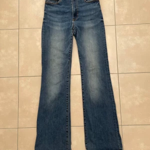 Bootcut Jeans - Ett par snygga mörkblå jeans i storlek 42, bra skick. Jeansen är stretchiga vilket ger en bekväm passform och midjelängden är hög. Innerbenslängden är 85 cm.