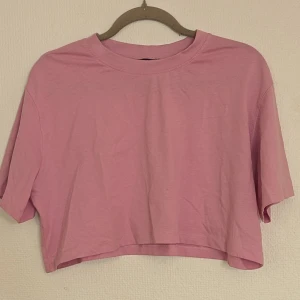 Rosa croppad topp från Zara - En rosa croppad topp från Zara med korta ärmar och rund hals. Tillverkad i bomull och passar perfekt för en avslappnad sommarstil.