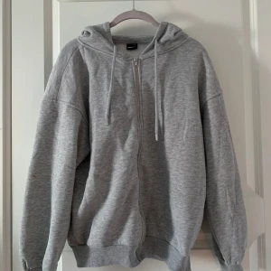 Grå zip hoodie  -  En grå Zipp hoodie från Gina. Bra skick.