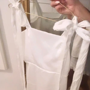Satinklänning - Fin satinklänning i nyskick, endast testad, prislapp kvar. Gömd dragkedja i ryggen, axelbanden går att knyta som man vill🤍