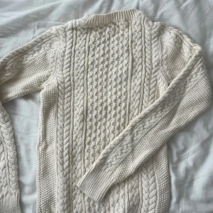 Krämvit stickad tröja - Säljer denna superfina vita stickade tröjan i jättefint skick då den inte kommer till användning. Den är i strlk XS och passformen är ganska tajt vilket är väldigt fint!❤️Skriv för fler bilder och frågor, pris kan diskuteras😊