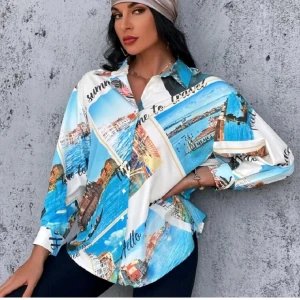 Flerfärgad skjorta med sommartryck - En flerfärgad skjorta med sommartryck som visar olika landskap och text som 'Hello summer'. Skjortan har långa ärmar och en lös passform, perfekt för en avslappnad sommarlook. Oanvänd. 100% ny. 