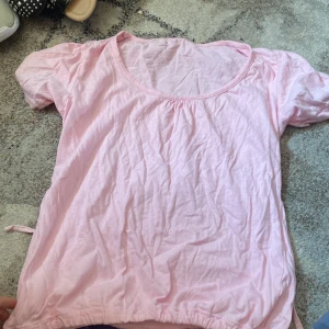  En lite gulligare t-shirt -  En rosa supersöt bomull t-shirt som man kan dra åt nere vid midjan storlek M