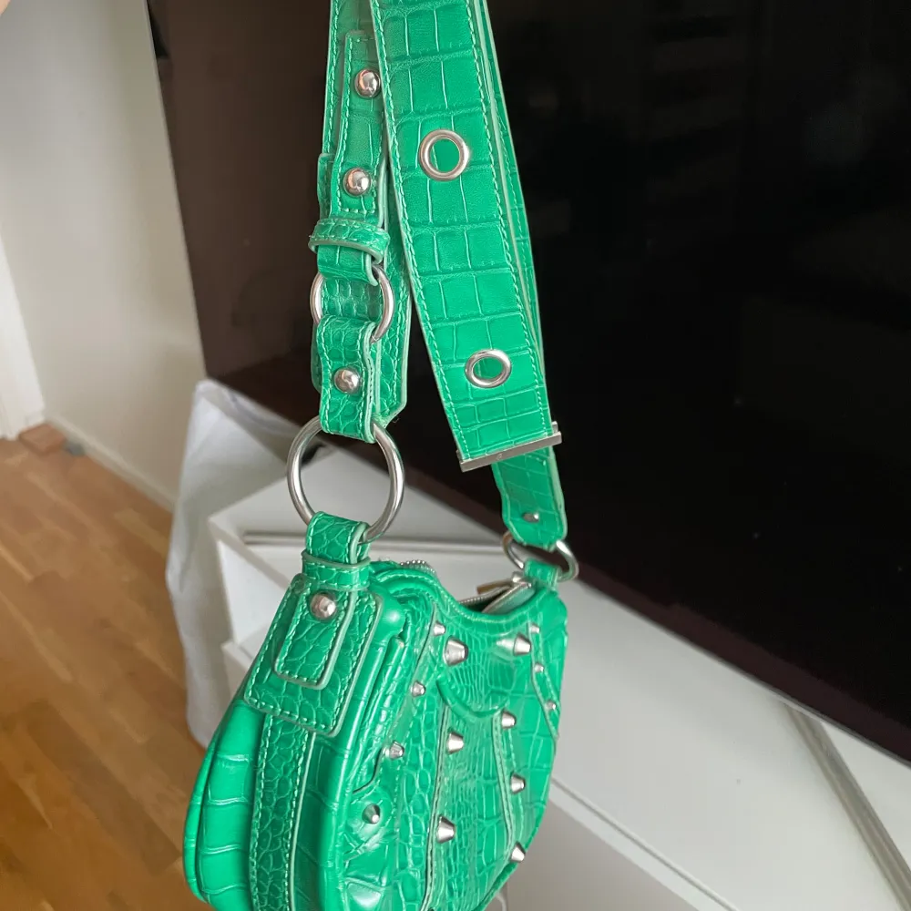 Skit snygg grön väska från asos, använt en del.  Skit snygga silver detaljer och du kan reglera bandet. Väskor.