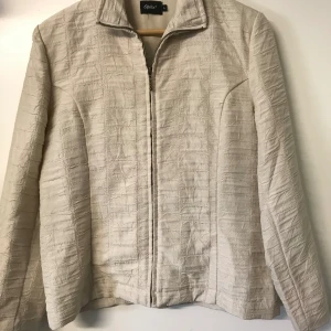 Beige tunn jacka  - Jacka av märket Ofelia, mycket obetydligt använd hel och ren. Storlek L 