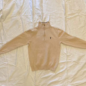 Polo Ralph Lauren halfzip - Säljer den här Polo Ralph Lauren Halfzipen. Skick: 9/10. Inga hål eller fläckar. Passar perfekt till sommarkvällar eftersom att det är ljust och tunt tyg som lätt släpper igenom värme. Säljer den för att jag har växt ur den.
