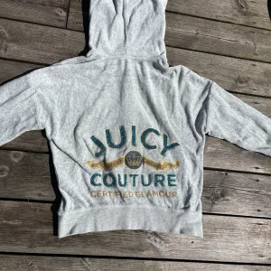Grå Juicy Couture zip hoodie - Den är knappt använd. Ovanlig modell köpt i USA där trycket på ryggen är med swarowski-kristaller (sista bilden).