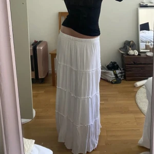 Lång vit kjol - Säljer denna vita långa kjolen eftersom jag inte haft någon användning av den. Är köpt här på Plick och första bilden är lånad av den jag köpte kjolen av! Materialet är lite vågigt och om man har på sig kjolen ser man inte igenom💕Aldrig använd!!