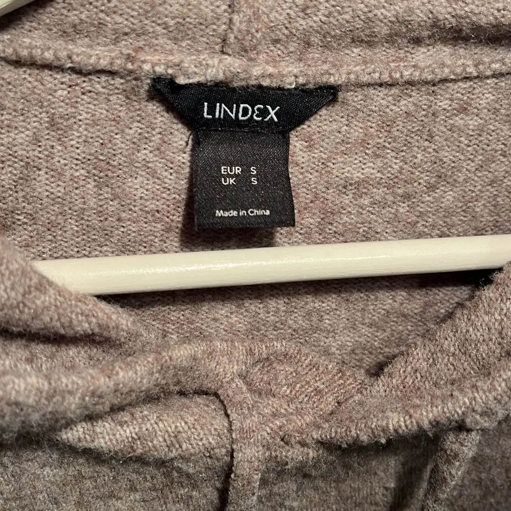 En snygg grå hoodie i storlek S men funkar för de som bär M. En snygg grå/ beige hoodie som är lite oversized från Lindex!. Hoodies.