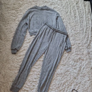 Mjukis set - Ett grått mjukis set i nysick. Aldrig använt. Toppen är lite cropped och byxorna har snörning i midjan som går dra åt och knyta. Båda delar är stl S.