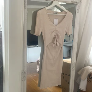 Beige klänning - Beige klänning aldeig använd, prislapp på. Storlek M/L och väldigt stretchig. Priset är ekl.frakt, kan mötas upp 🤍