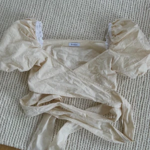 Rodebjer - Knytblus i nyttskick från Rodebjer, aldrig använt. Superfin gul-beige färg, perfekt till sommartillställningar.  Nypris 2295 SEK.
