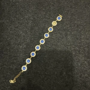 Armband från Lilly rose.  - Nypris 995:- Blå stenar  Guld metall En Sten har ramlat..men det är inget man tänker på när den är på handleden.