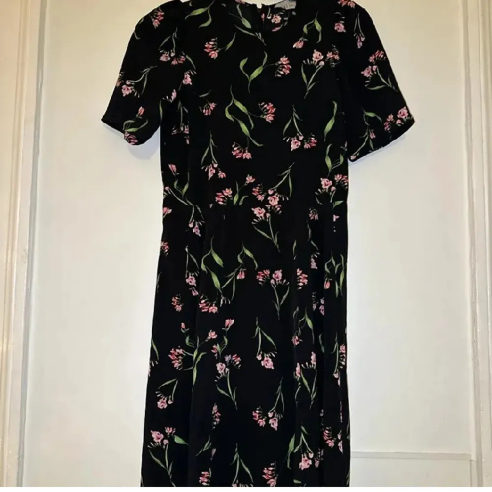 Denna klänning från H&M är i bra skick och perfekt till alla tillfällen! Den är inte tight i midjan och rätt så lång. Fint mönster med rosa blom buketter och gröna löv. Storlek EU 38/US 8. Klänningar.
