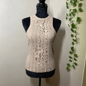Tank top - Säljer en fin topp från Hm. Beige brun färg använd en gång. Var inte riktigt min stil