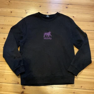 90s vintage stüssy tröja - En mycket trendig och snygg vintage Stüssy tröja 90s version. Ganska använd, lite sliten och ett litet hål vid armbågen men annars bra skick. Tillverkas inte längre så det finns dessvärre inget nypris. Sitter som en S men funkar bra till M. :)