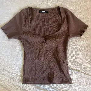 Säljer min jättegulliga bruna tajta urringade t-shirt. Passar bäst om man har t.ex ett spetsigt vitt linne under om man inte vill ha så mycket urringning. Aldrig använt så är i mycket bra skick!❤️för fler bilder kom privat!
