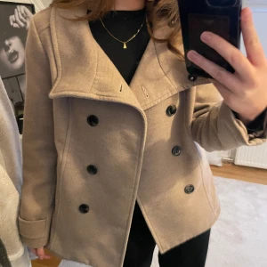 Kort kappa - Beige kort kappa. Står st 42 på lappen men passar mig bra som har st S