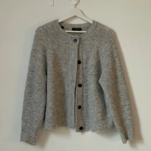 Stickad cardigan - Så fin stickad cardigan i ull från SELECTED FEMME! Endast testad! Nyskick! Färgen är light grey melange. 39% ull, 20% alpacka ull. Nypris 679kr
