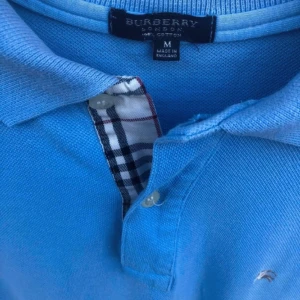 Burberry Piké - Säljer nu en riktigt fet och stilren Burberry piké! Skick 8/10, inga märkbara defekter. Står storlek M men passar mer som en L. Mått kan skickas ✅