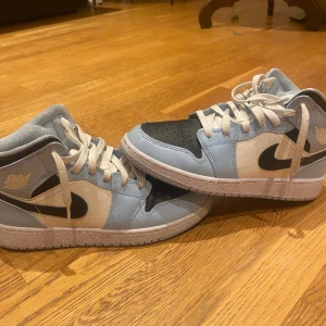 Jordan 1 mid ice blue black  - Säljer just nu mina gamla Jordans för de är för små. De är i storlek 38,5. De är i 8/10 skick. De har en liten crease på ena av skorna som knappast är synbar. Om man köper får man med box. Kan tänka mig att gå ner i pris.