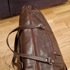 Weekend bag  - Vintage weekend bag i äkta kalvskinn Mått: L50 xH 25 x B 21 cm magnet ficka och en dragkjedje ficka utanpå två fickor invändigt för viktiga föremål finns hakar för å spänna fast axelremmen om man inte vill använda den 