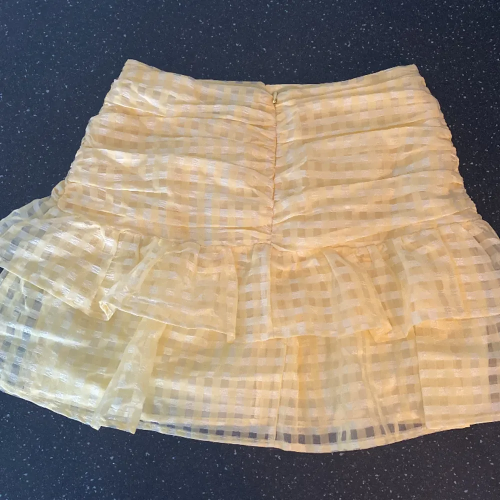 En kort kjol med volanger, jättefin modell till sommaren. Använd 3 gånger Max, jättefint skick. (Säljer då den inte kommit till så mkt användning - har massor av sommarkjolar). Kjolar.