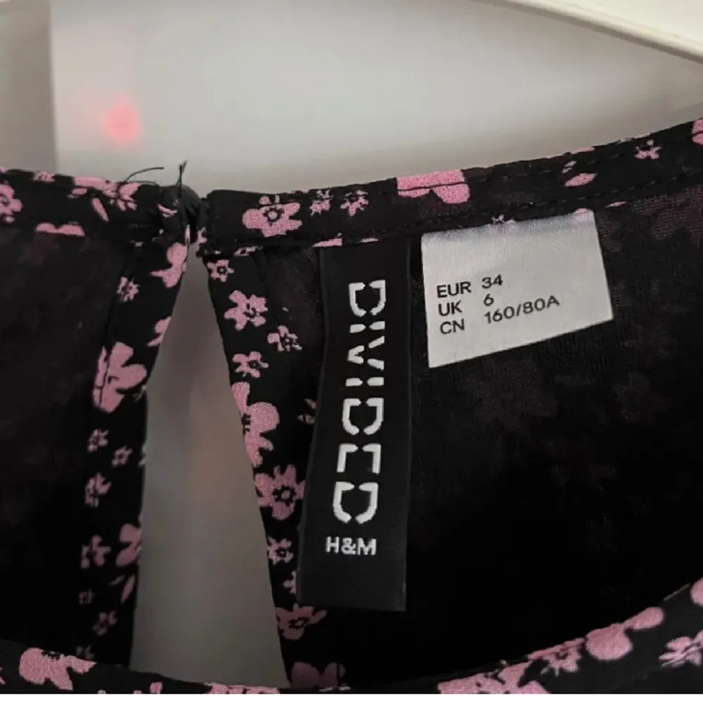 En supergullig svart klänning med rosa-lila blommor från H&M i strl 34!💓. Klänningar.