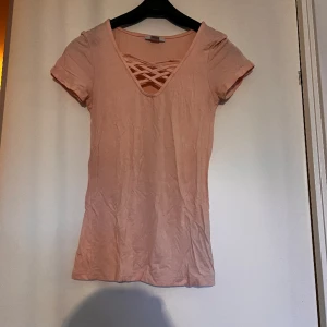 T-shirt  - T-shirt med liten snörning. Skönt material och bekväm, endast använd några få gånger och är i fint skick.