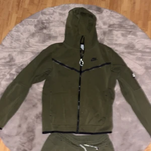 Grön Nike tech - Säljer min mörkgröna Nike tech då jag inte använder den längre. Köpte den i somras. Storlek S men passar även M