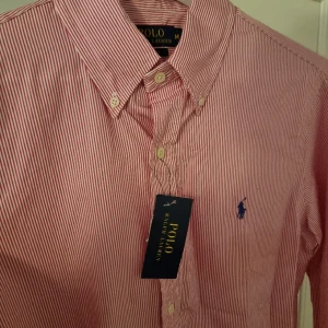 Ralph lauren skjorta NY - Helt ny och oanvänd ralph lauren skojrta i snyggt randigt mönster nypris 1200. Kan gå ner i pris vid smidig affär Hör av er vid frågor