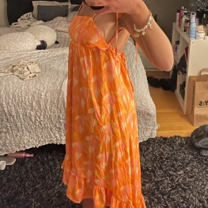 Sommarklänning  - Lång sommarklänning som är längre där bak med öppenrygg, superfin med justerbara band vid midjan och som man kan knyta lite som man vill! 🧡