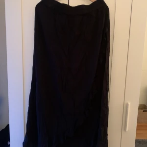 Lång svart kjol med slit - Lång svart med ett slit nästan hela vägen,Obs väldigt skrynklig på bild kan strykas inan den sickas