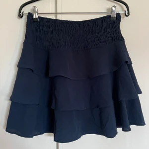 Blå volangkjol  - En mörkblå volangkjol från Veromoda. Med resår i midjan.  Väldigt fint skick, stl S. 