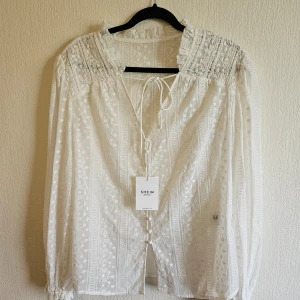 Blus  - Ny blus med fin mönstrat tyg.  Storlek s men lite stor i Storleken. Färgen mellan vit och crèmefärgad.