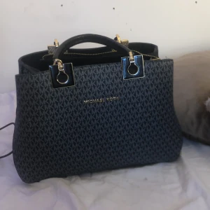 Fejk michel kors väska - Fejk michael kors väska i bra skick. Har ett längre band som dock är sönder men annars har den inga skador eller så