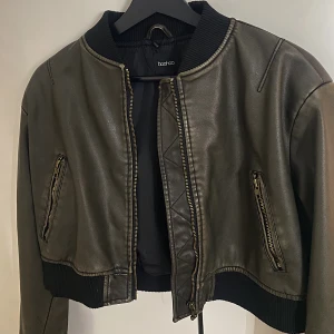 CROPPAD BOMBERJACKA  - En snygg läder bomberjacka i vintagestil. Storlek 36, och i nyskick! 