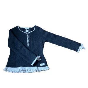 Coquette tröja - Jätte söt stickad tröja med rosetter på armarna. Jätte bra skick, bara lite nopprig som stickade tröjor blir, och lite missfärgad på halsen. Går att göra tightare med snörerna på ryggen.