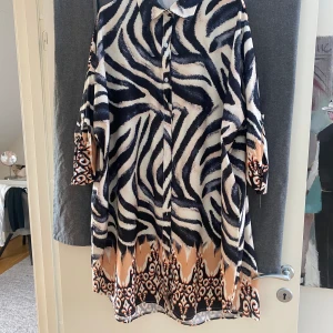 Storskjorta/ klänning  - Härligt mönstrad klänning i zebramönster med inslag av aprikos färgen alltså. 