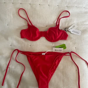 Röd bikini NA-KD - Aldrig använd med prislappar kvar! Köpt för 399kr. Överdel och underdel säljs tillsammans. Strl S i underdel och 75B i överdel. 