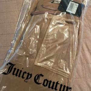 Juicy couture  - Juicy couture byxor med fickor där bak ända täckney på användning är att metallbitar är borta på båda snörerna använda fåtals gånger 