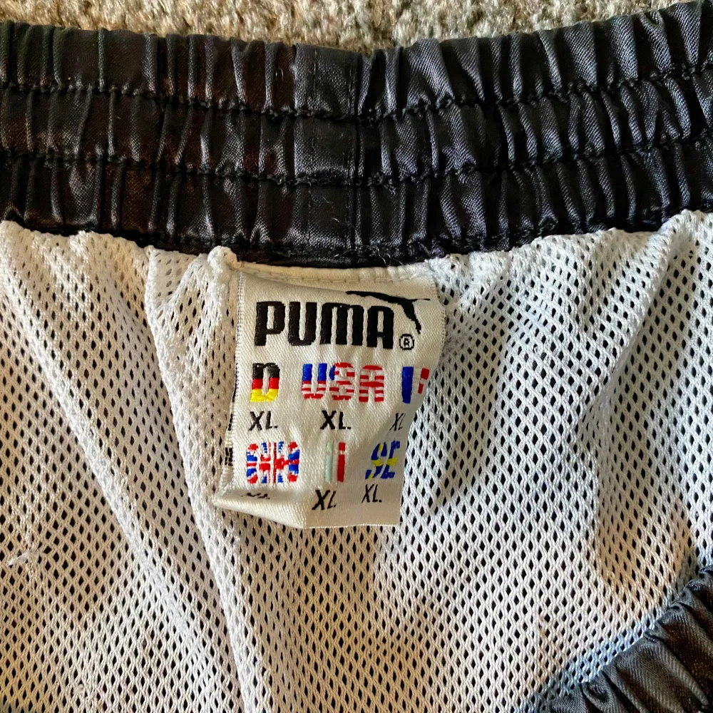 Svarta glansiga Puma shorts stl XL i bra skick,enstaka tråddrag kan förekomma men i bra skick!. Shorts.