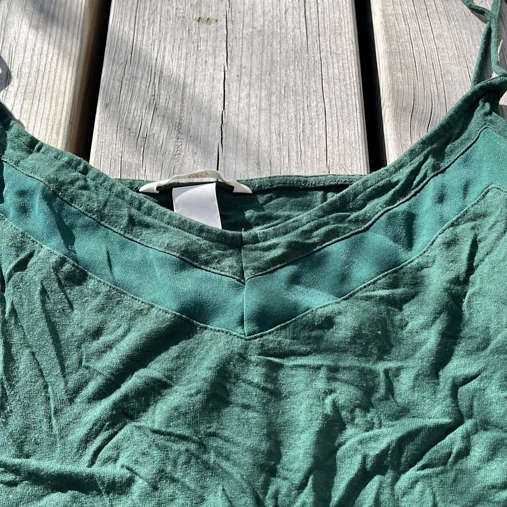 Vackert mörkgrönt linne från H&M med fin detalj framtill 🫶🏽 . Toppar.