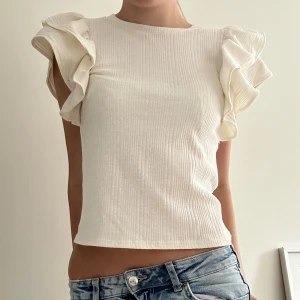 Zara tröja - Vit zara t-shorts med volanger. I storlek s som säljs pågrund av att den inte används längre. Pris kan diskuteras 