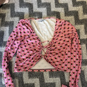 Rosa crop top med nyckelhålsdetalj - En långärmad mönstrad magtröja med nyckelhålsdetalj från Breshka. Bra kvalite, trots storleken L skulle jag påstå att den är mer storlek M