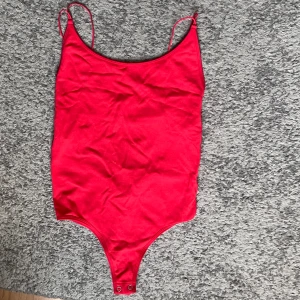 Röd body med öppen rygg - Oanvänd body med öppen rygg.