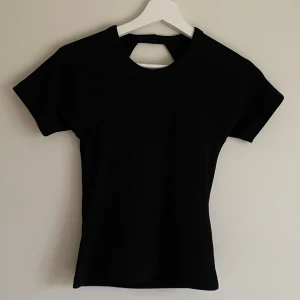 T-shirt med öppen rygg - Svart t-shirt med öppen rygg, aldrig använt. Jag köpte den på Nelly men de står ”JJXX” på lappen.❣️