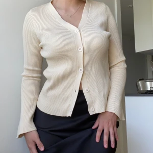 Beige långärmad kofta  - En väldigt fin kofta i beige.  Så skön att bära, tjock material. Aldrig använt. 