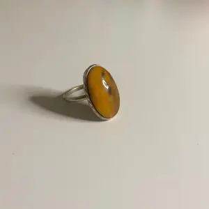 Cool ring i silver och någon gul kristall, skulle kunna vara tigeröga